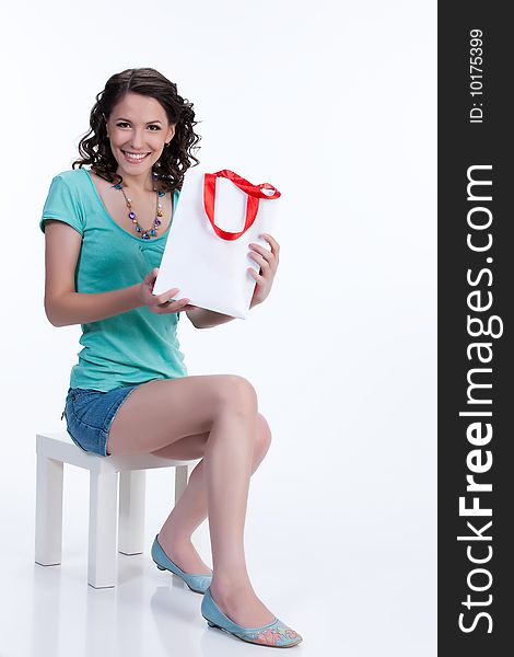 Young emotional woman on isolated background with paper bag laughing