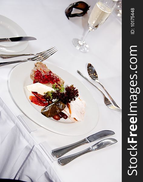 Place setting with meal including utensils and wine in glass