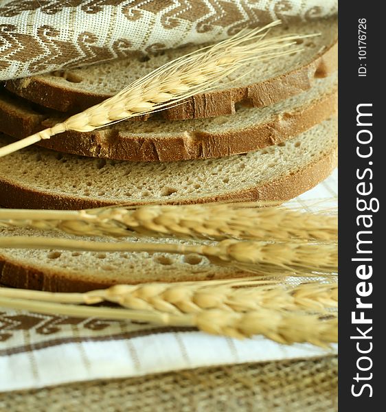 Wheat ears and bread with kitchen towel