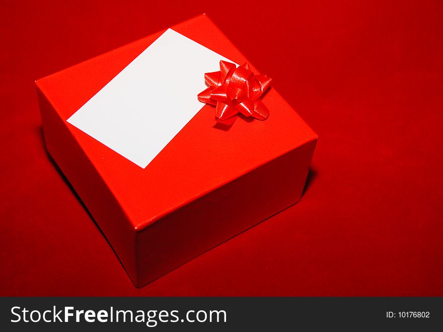 Red box with a card & a red bow on red background. Red box with a card & a red bow on red background