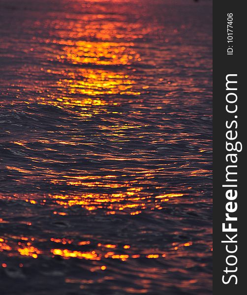 Colorful ripples as sun sets over water. Colorful ripples as sun sets over water