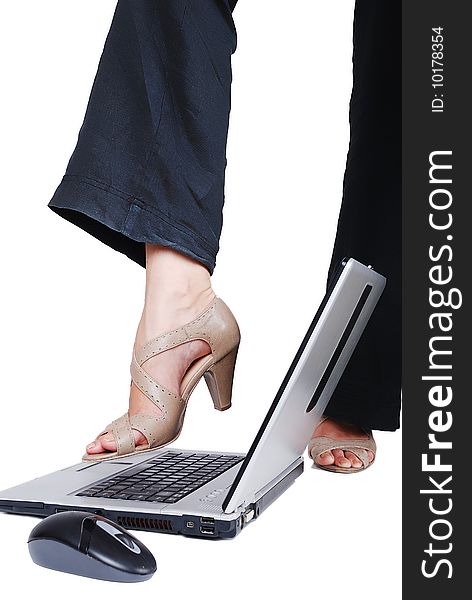 Female leg above the laptop about to crash it. Female leg above the laptop about to crash it