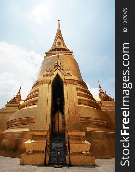 Thai golden pagoda at Wat Prakaew in summer blue sky