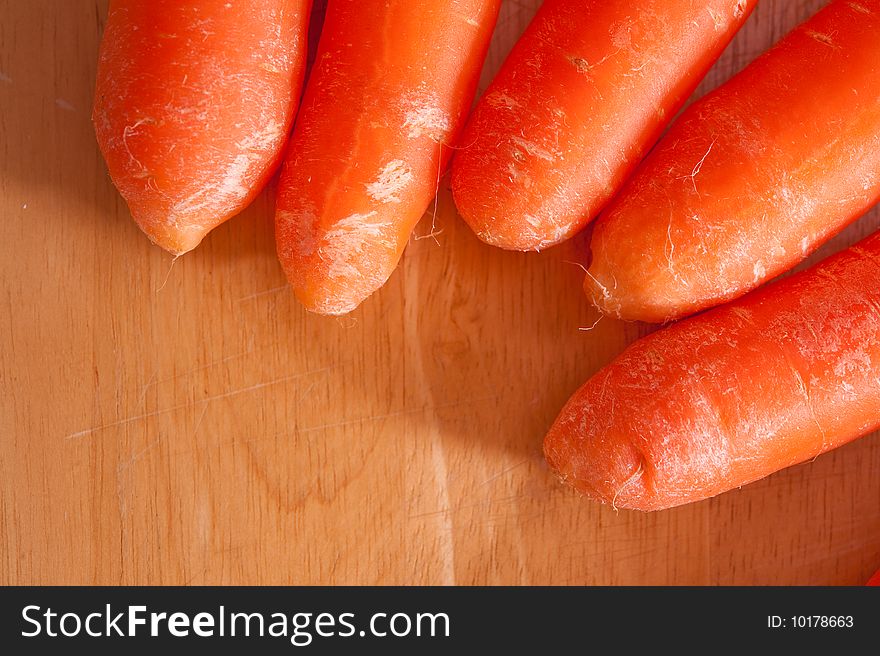 An image of carrots on a wooden chopping board. An image of carrots on a wooden chopping board