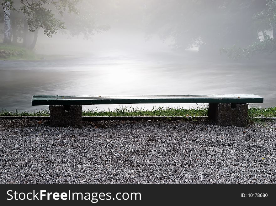A bench aside the river in morning time