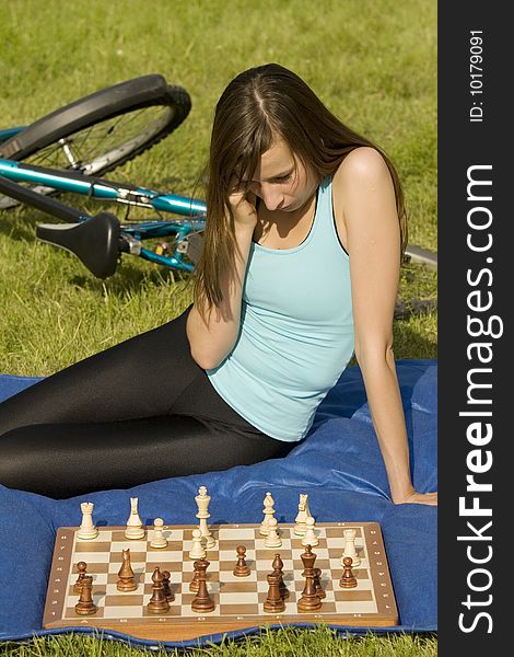 Female student playing chess game outdoor