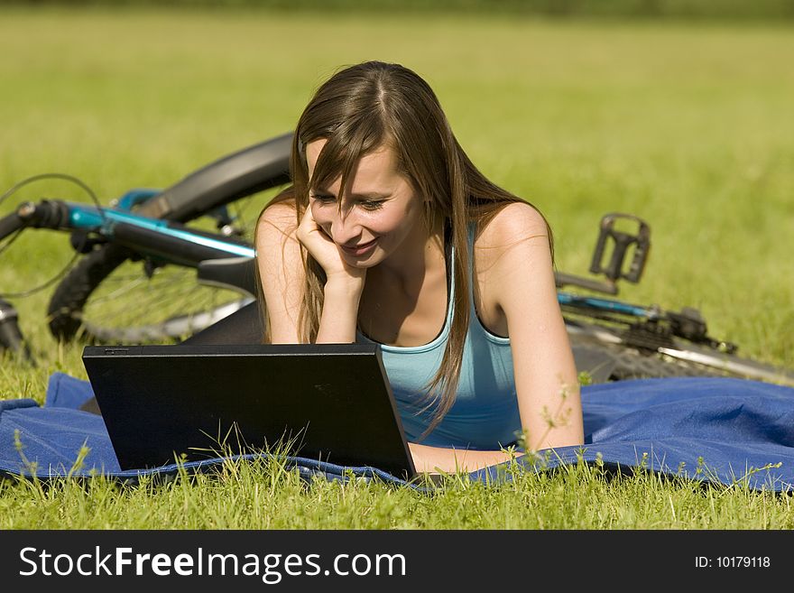 Female student with laptop relaxing on the grass. Female student with laptop relaxing on the grass