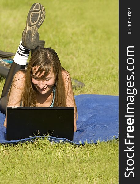 Female student with laptop relaxing on the grass. Female student with laptop relaxing on the grass