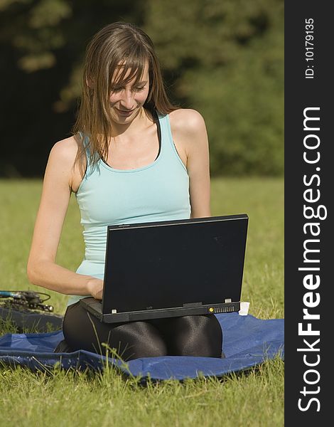 Female student with laptop working in the park. Female student with laptop working in the park