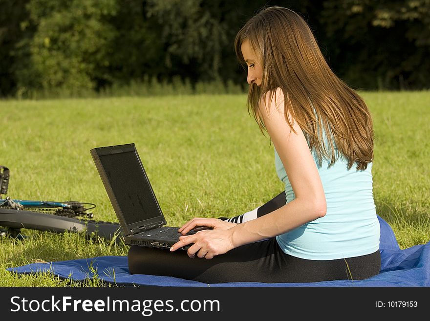 Female student with laptop relaxing on the grass. Female student with laptop relaxing on the grass