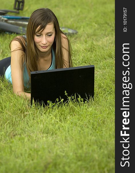 Female student with laptop relaxing on the grass. Female student with laptop relaxing on the grass