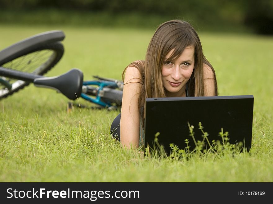 Female student with laptop relaxing on the grass. Female student with laptop relaxing on the grass