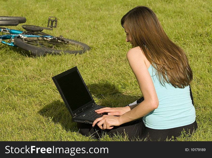 Female student with laptop learning on the grass. Female student with laptop learning on the grass