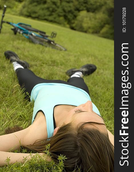 Woman relaxing on grass after sport exercises