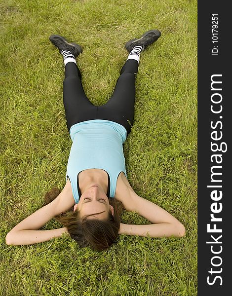 Woman relaxing on grass after sport exercises