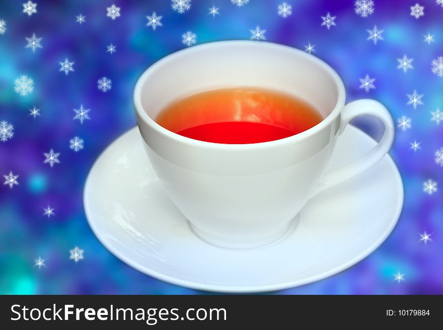 Big cup of tea in front of blue background with snowflakes allover. Big cup of tea in front of blue background with snowflakes allover