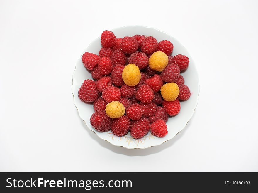 Red and yellow raspberries in the bowl, isolated. Red and yellow raspberries in the bowl, isolated