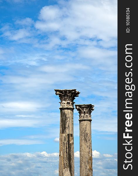 Two old marble columns against the blue sky