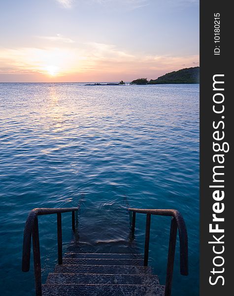 Natural sea swimming pool with staircase and sunset