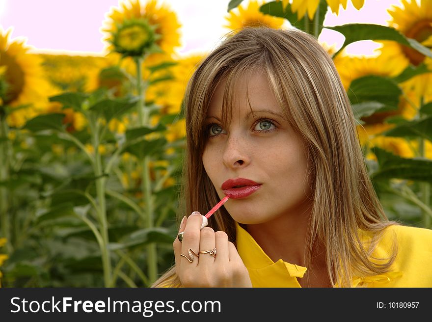 Portrait Of Beauty Young Woman Applying Lipstick