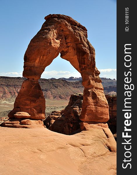 Delicate Arch in Arches National Park Utah. In the distance through the arch is South Window. Delicate Arch in Arches National Park Utah. In the distance through the arch is South Window