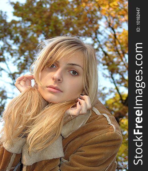 The bright colours of the late autumn contrasting with the beauty of the nice blond model. Was shot in Russia in 09.10.2004 at sunset. The bright colours of the late autumn contrasting with the beauty of the nice blond model. Was shot in Russia in 09.10.2004 at sunset.