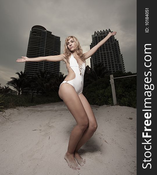 Young woman posing in a bathing suit with buildings in the background. Young woman posing in a bathing suit with buildings in the background