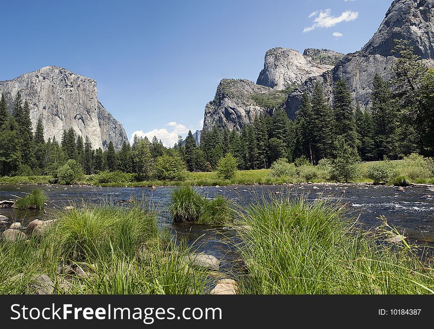 View of Yosemite Valley with a River in the foreground and Mountains in the background. View of Yosemite Valley with a River in the foreground and Mountains in the background