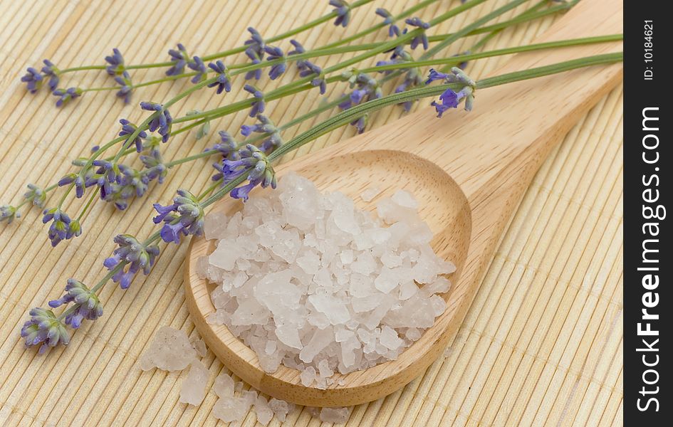 Sea saltin in a wooden spoon and lavender. Sea saltin in a wooden spoon and lavender