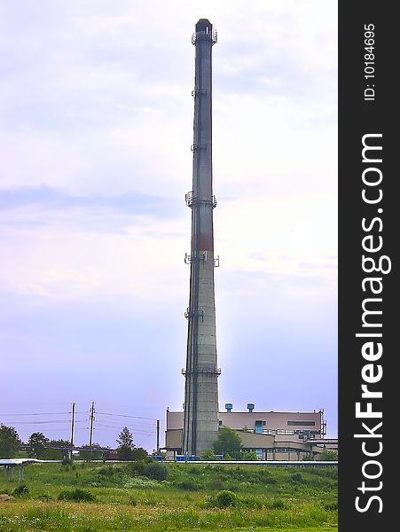 Factory, with the high concrete pipe, represented, against a green grass and the dark blue sky. Factory, with the high concrete pipe, represented, against a green grass and the dark blue sky