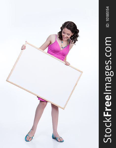 Young attractive woman holding white board surprising. Young attractive woman holding white board surprising