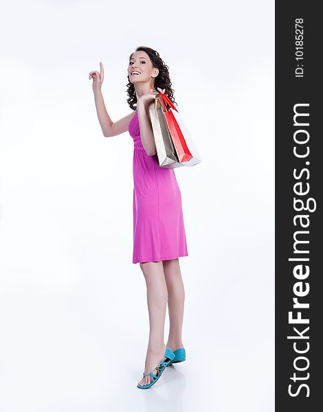 Young woman with shopping bag and raised hand smiling. Young woman with shopping bag and raised hand smiling