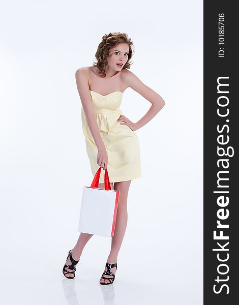 Young woman with shopping bag wondering. Young woman with shopping bag wondering