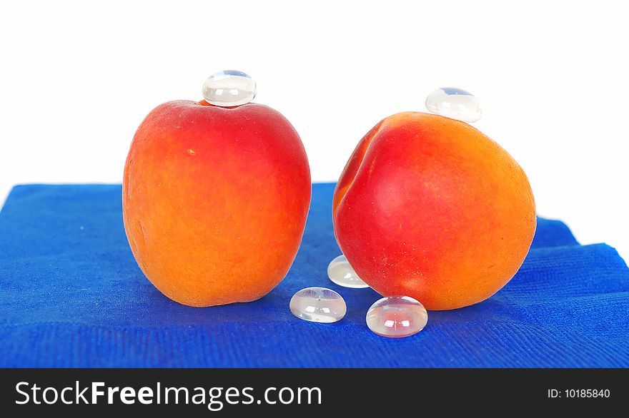 Juicy apricots on the blue with glass drops . Juicy apricots on the blue with glass drops .