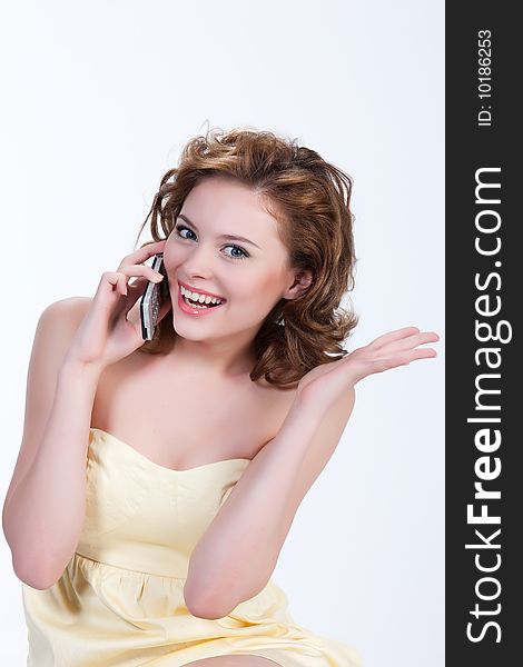 Young attractive emotional woman on isolated background speaking over the mobile phone. Young attractive emotional woman on isolated background speaking over the mobile phone