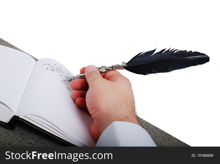 Male hand is writting on paper by the feather. Male hand is writting on paper by the feather