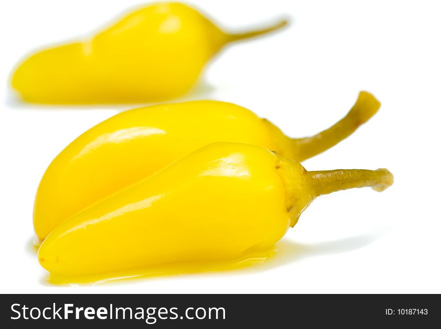 A group of yellow chilli peppers on white background.