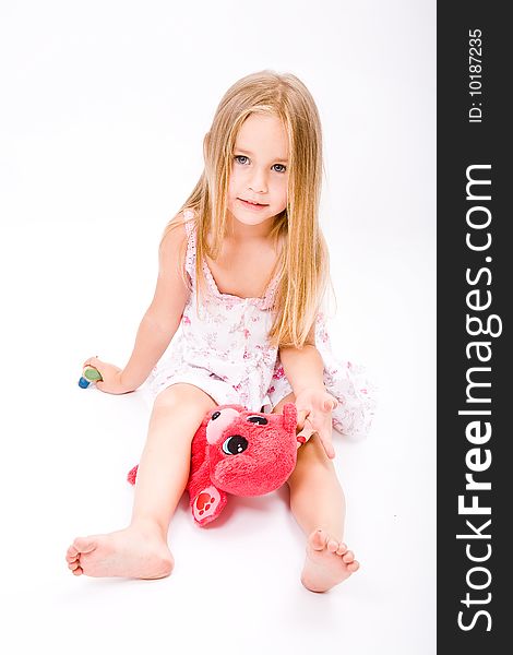Beautiful little girl with long blonde hair and red bear