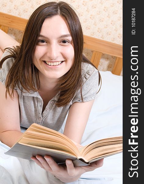 Smiling student  reads a book