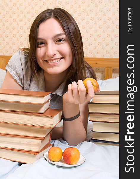 Portrait of young woman with peach and books. Portrait of young woman with peach and books