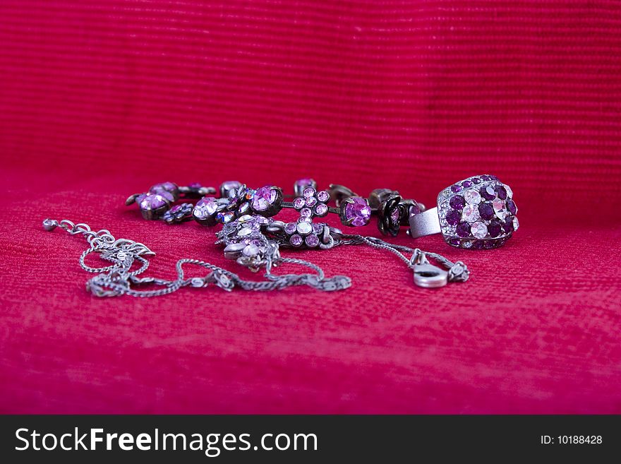 Old cheap jewelry on red background. Old cheap jewelry on red background