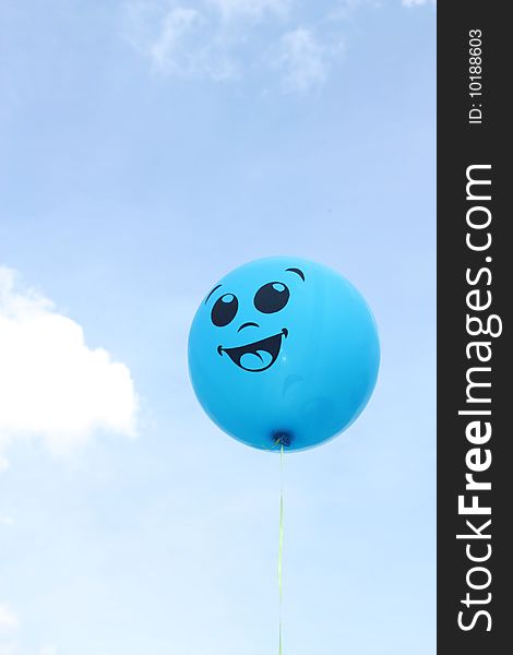 Balloon a smile in the blue sky with clouds.