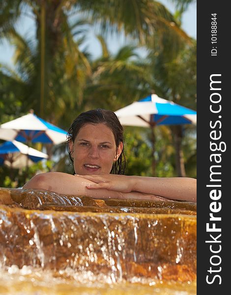 Young woman in a beautiful pool with palms in the background. Young woman in a beautiful pool with palms in the background.