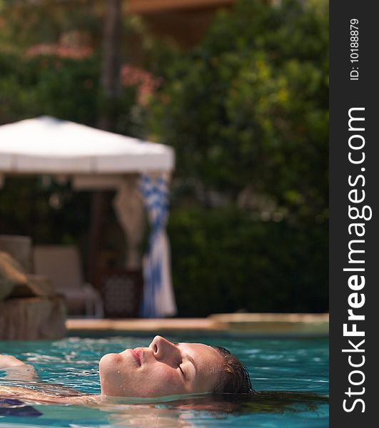 Young woman in a beautiful pool with palms in the background. Young woman in a beautiful pool with palms in the background.