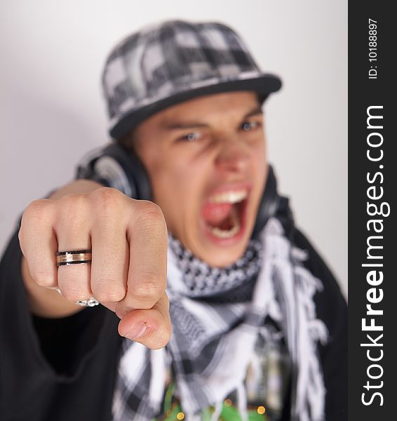 A young DJ is pointing at the camera and screaming. The focus is on his fist! Isolated over white. A young DJ is pointing at the camera and screaming. The focus is on his fist! Isolated over white.
