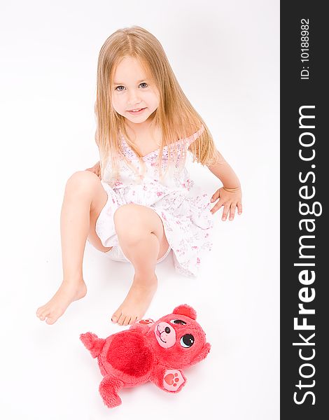 Beautiful little girl with long blonde hair and red bear