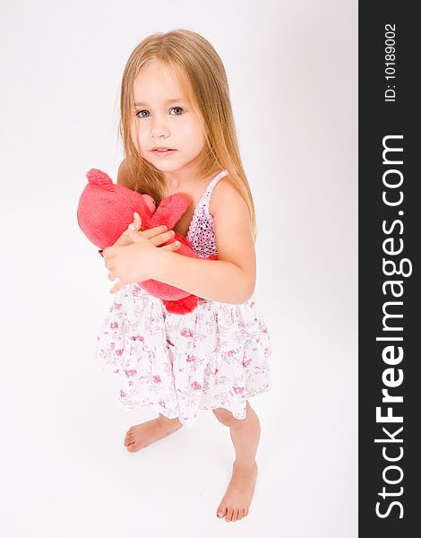 Beautiful little girl with long blonde hair and red bear