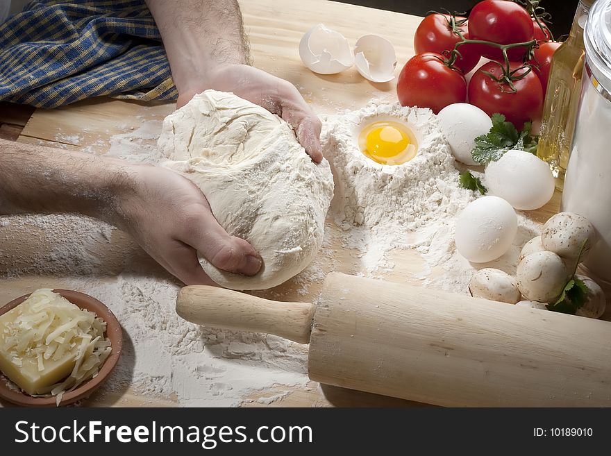 Overhead shot of a man kneading a dough on a wooden  table. Overhead shot of a man kneading a dough on a wooden  table