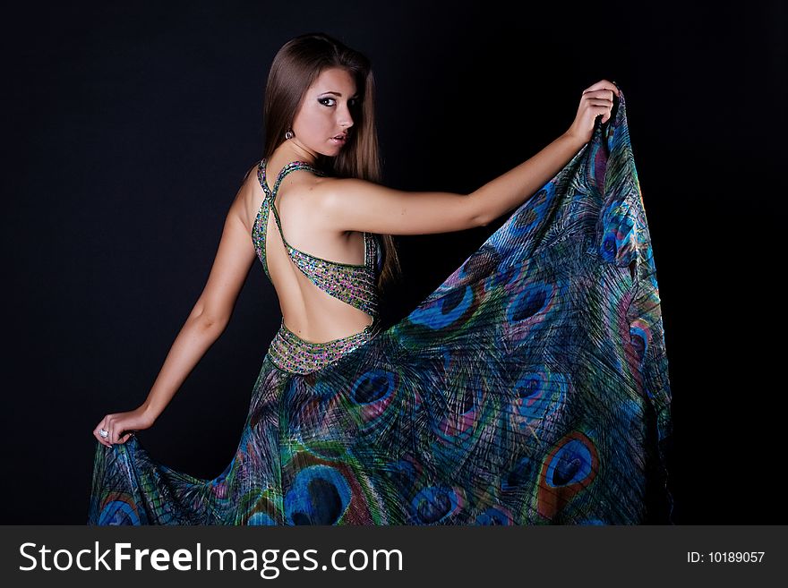 Young woman in beautiful long dress isolated on black