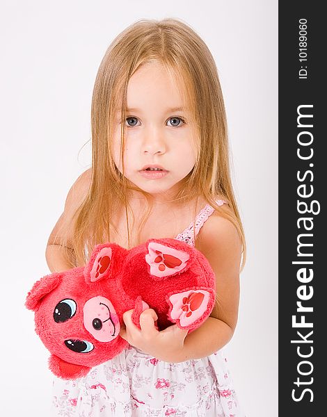 Beautiful little girl with long blonde hair and red bear